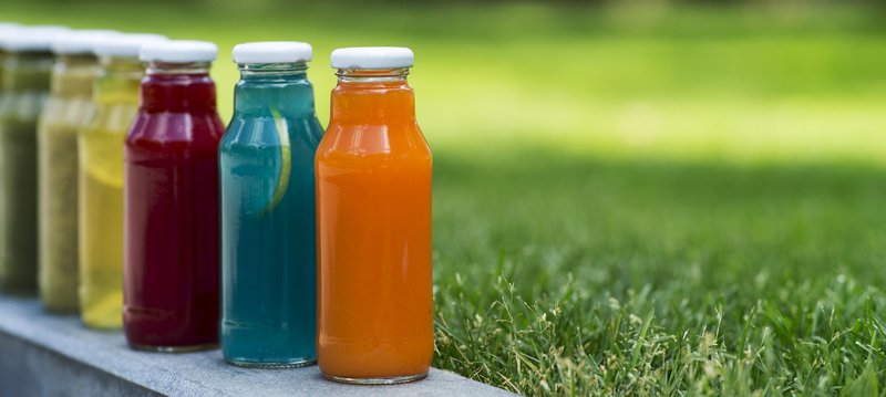 butelki z sokami w trawie