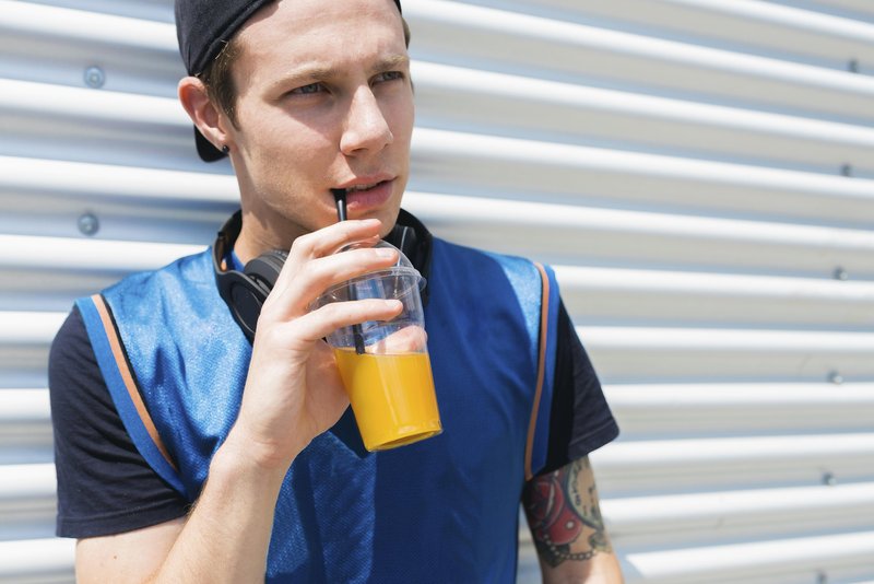 chłopak w czapce sok pomarańczowy