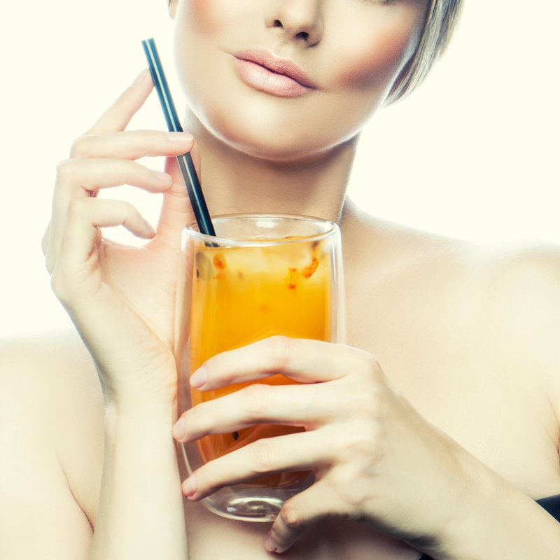 sok pomarańczowy w dłoniach kobiety